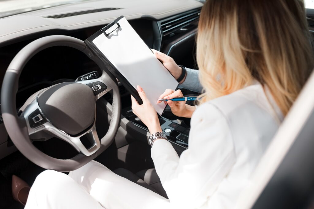 Woman signs a deal with a car dealership about buying, leasing car